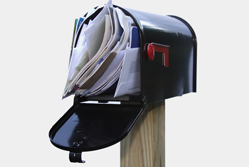 Open letter box filled with junk mail