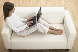 Woman sitting on sofa with a laptop