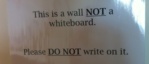 Sign saying 'this is a wall not a whiteboard'