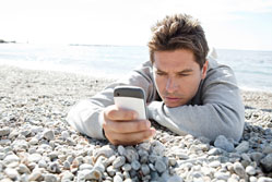 Man using phone on beach{{}}